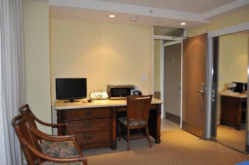 a room with a desk with a computer and a television at Mana Kai Maui - Official Onsite Rental Company in Wailea
