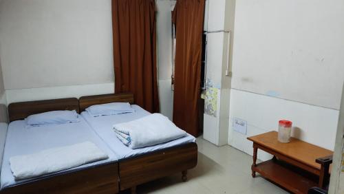 a bedroom with a bed with two pillows and a table at Hotel Prithviraj in Ajmer