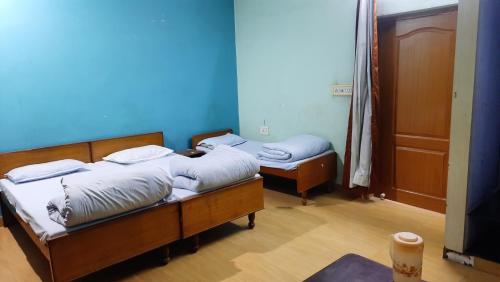 two twin beds in a room with a tv at Hotel Prithviraj in Ajmer