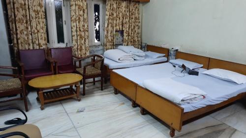 Habitación con 3 camas, mesa y sillas en Hotel Prithviraj, en Ajmer