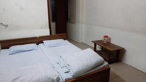 a bedroom with two beds and a small table at Hotel Prithviraj in Ajmer