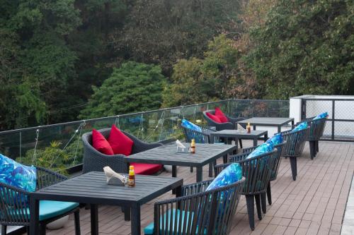 a row of tables and chairs on a balcony at The Oasis Mussoorie - A Member of Radisson Individuals in Mussoorie