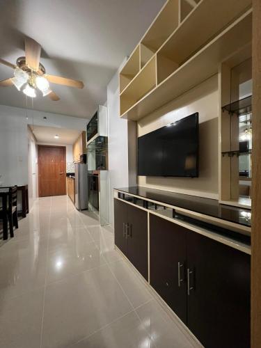 a large living room with a flat screen tv on a wall at ARISE shell Residences in Manila