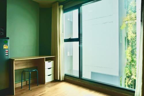 a room with a desk and a large window at Hash Apartment with unique chill design at Silom Soi 3 in Bangkok