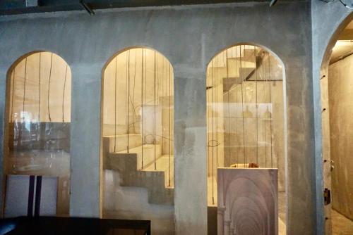 a room with three arched doors and a staircase at Hash Apartment with unique chill design at Silom Soi 3 in Bangkok