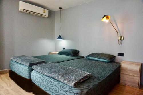 Chill apartment with unique design @ Silom Soi 3 في بانكوك: غرفة نوم بسريرين ومروحة