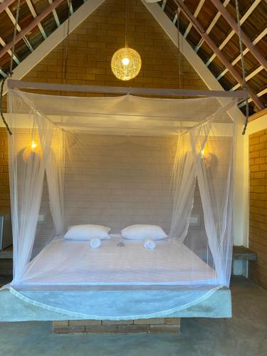 a bed in a room with a mosquito net at Summer Bell Midigama in Midigama
