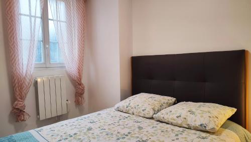 a bedroom with a bed with a black headboard and a window at La Sérénade - TOP Destination - Montreuil in Montreuil