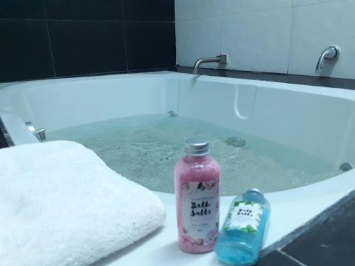 a bath tub with a bottle of soap and a towel at Aparta-Hotel CASA REAL Apartamentos in Chapala