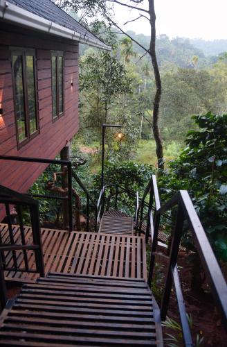 a wooden bench sitting on a porch of a house at TREE6 WAYANAD in Vythiri