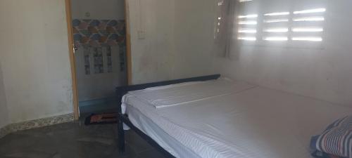 1 dormitorio con 1 cama en una habitación con ventana en Singleroom en Trincomalee