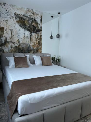 1 dormitorio con 1 cama blanca grande con almohadas marrones en Est One Apartament 2 camere semidecomandat, en Drobeta-Turnu Severin