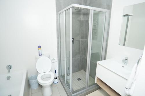 bagno bianco con doccia e servizi igienici di Fourways Oasis a Sandton