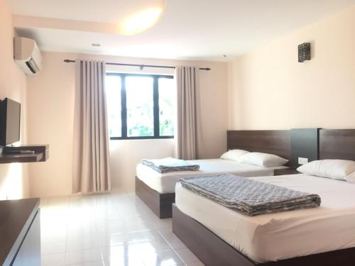 Cette chambre comprend 2 lits et une fenêtre. dans l'établissement Sunshine Lot 10 Pangkor, à Kampong Sungai Udang