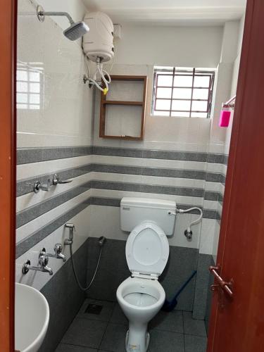 La salle de bains est pourvue de toilettes et d'un lavabo. dans l'établissement SM RESIDENCY, à Cochin