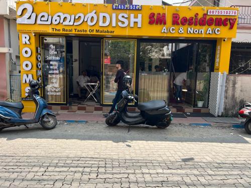 deux scooters sont garés devant un restaurant dans l'établissement SM RESIDENCY, à Cochin