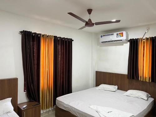 - une chambre avec un lit et un ventilateur de plafond dans l'établissement SM RESIDENCY, à Cochin