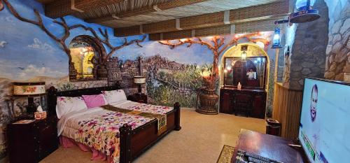 Fort Mughaibar Resort في حتا: غرفة نوم بسرير ودهان على الحائط