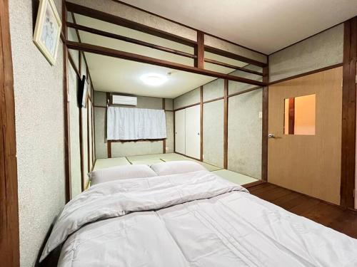 a bedroom with a large white bed in it at 最大８人様まで宿泊可能な１棟貸しです！近鉄八尾駅から徒歩３分！ in Yaochō