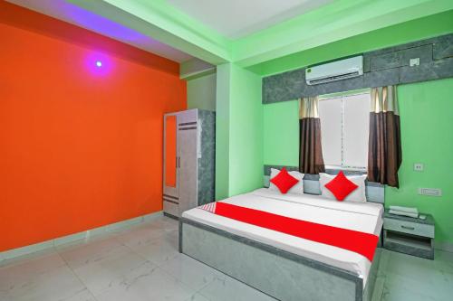 een slaapkamer met een bed met rode en groene muren bij Collection O Hotel 7dayz Inn Near City Centre 2 in Calcutta