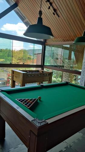 a pool table in a living room with a pool table at Charme do Chalé 17 em Gravatá in Gravatá