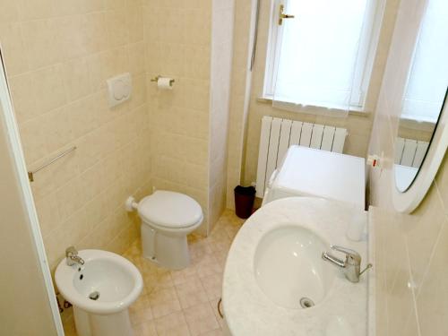 a bathroom with a white toilet and a sink at Grottammare mon amour Kira in Grottammare