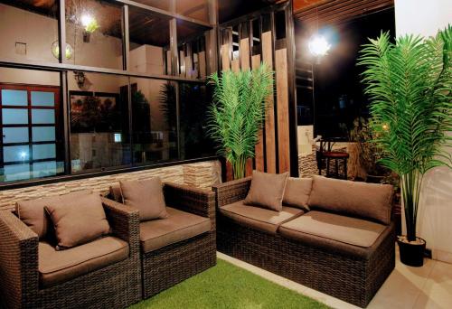 a restaurant with two chairs and two plants at Hotel del Valle in Huancayo