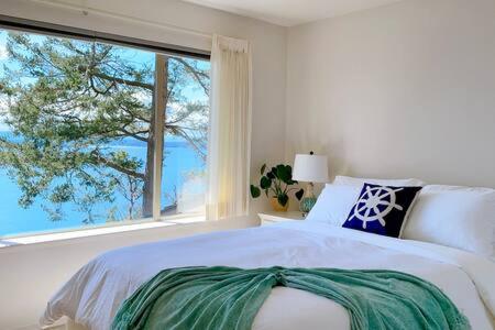 a bedroom with a bed and a large window at SaliHaven: Oceanfront 4Bedrooms 5Beds 3 5Bath in Bedwell Harbour