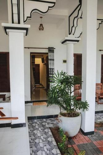 a house with a potted plant in the middle at Sunset View Beach Hotel in Arugam Bay