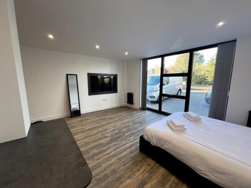 a bedroom with a large bed and a flat screen tv at Hospital View Apartment in Glenfield