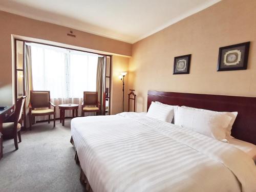 a hotel room with a bed and a table and chairs at Rosedale Hotel & Suites Guangzhou - Free Shuttle Bus to Canton Fair in Guangzhou