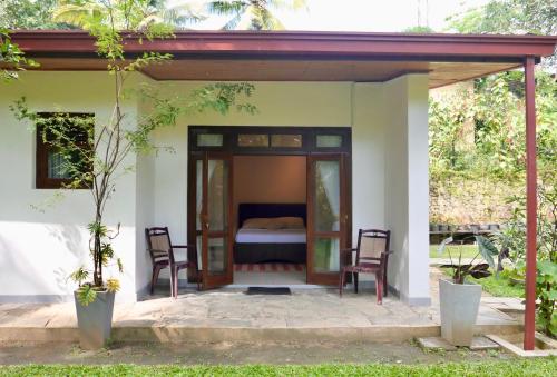 a guest house with a bed and two chairs at The Bliss Hostel Kandy in Kandy