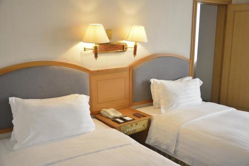 a hotel room with two beds and a telephone at Rosedale Hotel & Suites Guangzhou - Free Shuttle Bus to Canton Fair in Guangzhou