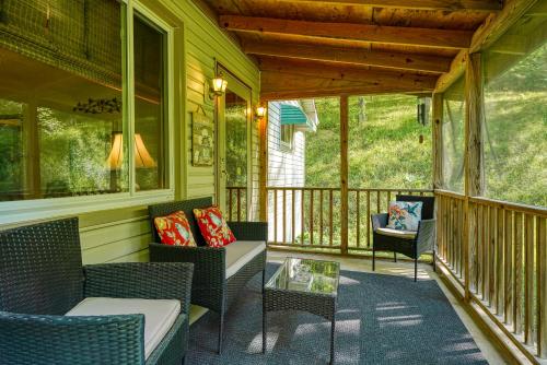a porch with wicker chairs and a glass table at Hillside Hideaway in Logan