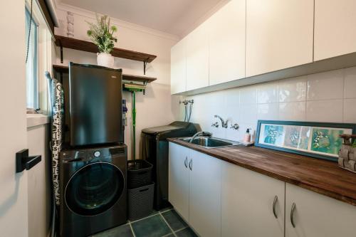a kitchen with a washer and dryer next to a sink at The Dunes in Ocean Grove