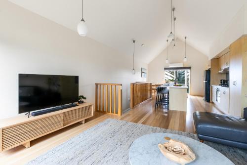 a living room with a large flat screen tv at The Dunes in Ocean Grove