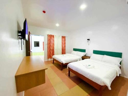 Kakisa ll Diving Resort في Bacong: غرفة بسريرين وطاولة فيها