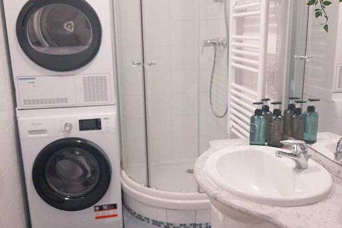 ein Badezimmer mit einer Waschmaschine neben einem Waschbecken in der Unterkunft Lovely three-room apartment near metro station in Saint-Denis