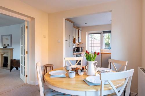 a dining room table with chairs and a table at Chaveney Cottage in Quorndon