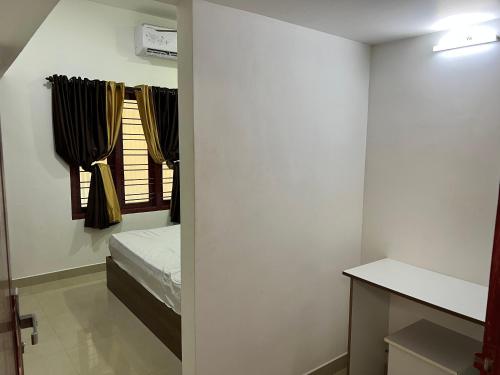 - une petite chambre avec un lit et une fenêtre dans l'établissement SM RESIDENCY, à Cochin