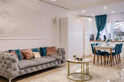 a living room with a couch and a table at Sika Garden Apartment- garaj privat cu intrare direct in apartament și grădină in Arad