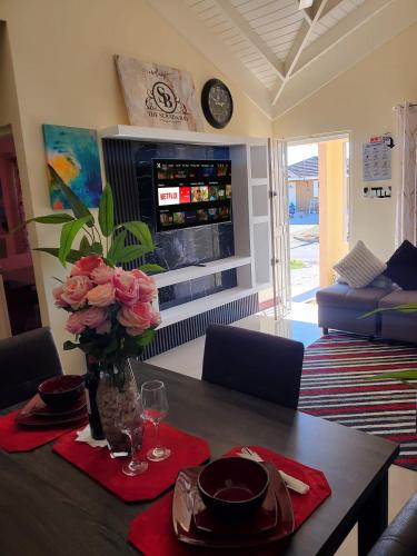 a dining room table with a vase of flowers on it at The Surada Bay in Old Harbour
