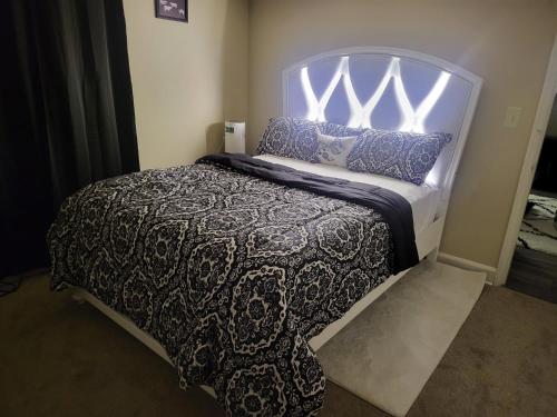a bedroom with a bed with a black and white comforter at kaysgroove in Alexandria