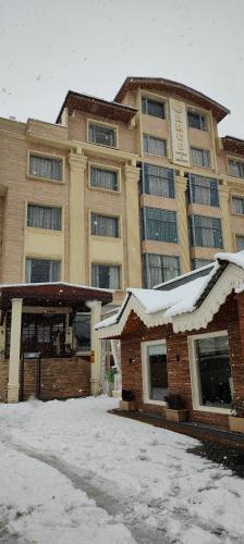 a large building with snow in front of it at ARCO Hotels and Resorts Srinagar in Srinagar