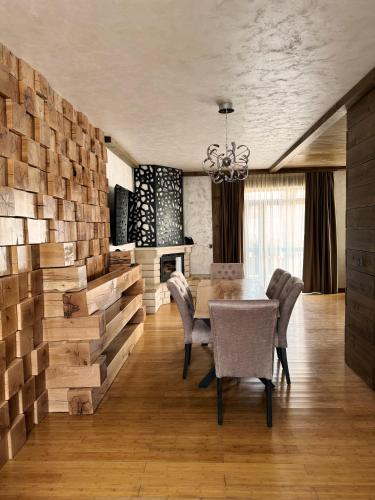 a dining room with a table and chairs and a fireplace at V Chalet Residence in Velingrad