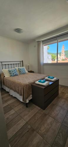 a bedroom with a bed and a large window at Departamento temporario en Salta la Linda in Salta