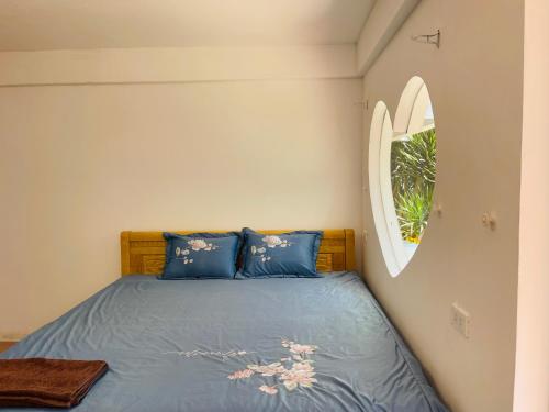 a bedroom with a bed with blue sheets and a mirror at Bãi Xếp Beach in Quy Nhon
