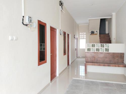 un pasillo con paredes blancas y una escalera en una casa en U Eleven Syariah Homestay, en Tangerang