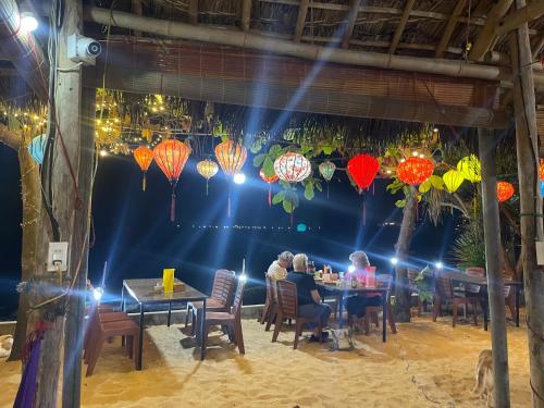 un grupo de personas sentadas en mesas en un restaurante en Bãi Xếp Beach en Quy Nhon