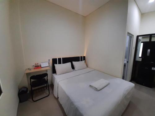 a small bedroom with a bed and a chair at TRAM - The Seturan Raya Eksklusif Rooms in Seturan